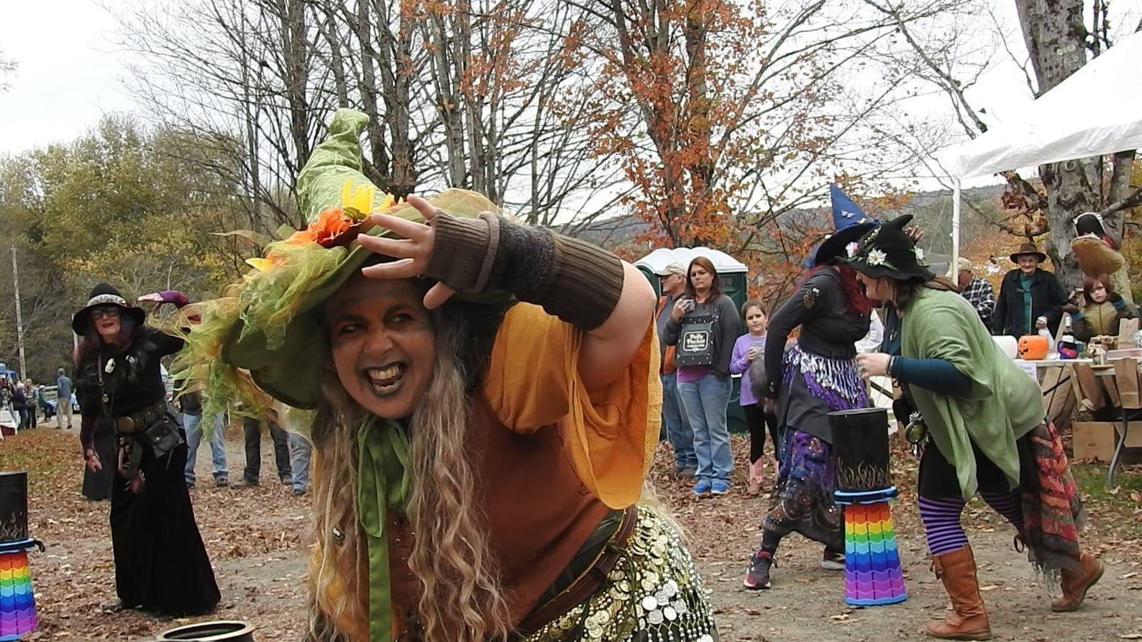 A person in an elaborate witch costume dancing at the Fall Festival